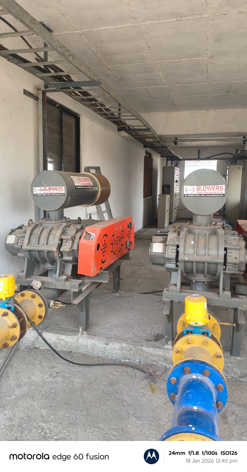Twin AEW root blowers installed in plant electrical room with pipeline and valves